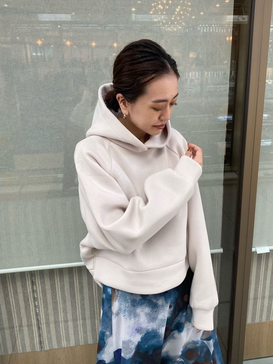 ブルー系のスカート、ブラック系のブーツ、ホワイト系のパーカーを着用したレディースの秋コーディネートの7枚目の写真