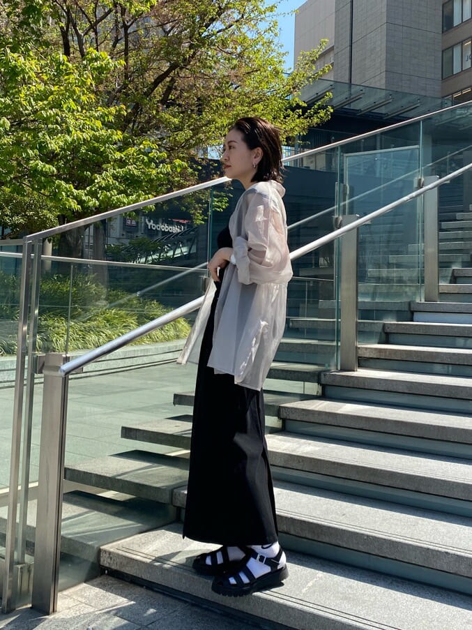 ブラック系のハンドバッグ、ブラック系のタンクトップ、グレー系のシャツ/ブラウスを着用したレディースの春コーディネートの2枚目の写真