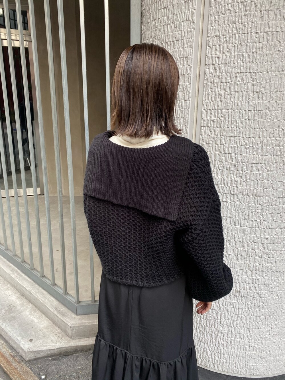 ブラック系のスカート、ホワイト系のニット/セーターを着用したレディースの冬コーディネートの5枚目の写真