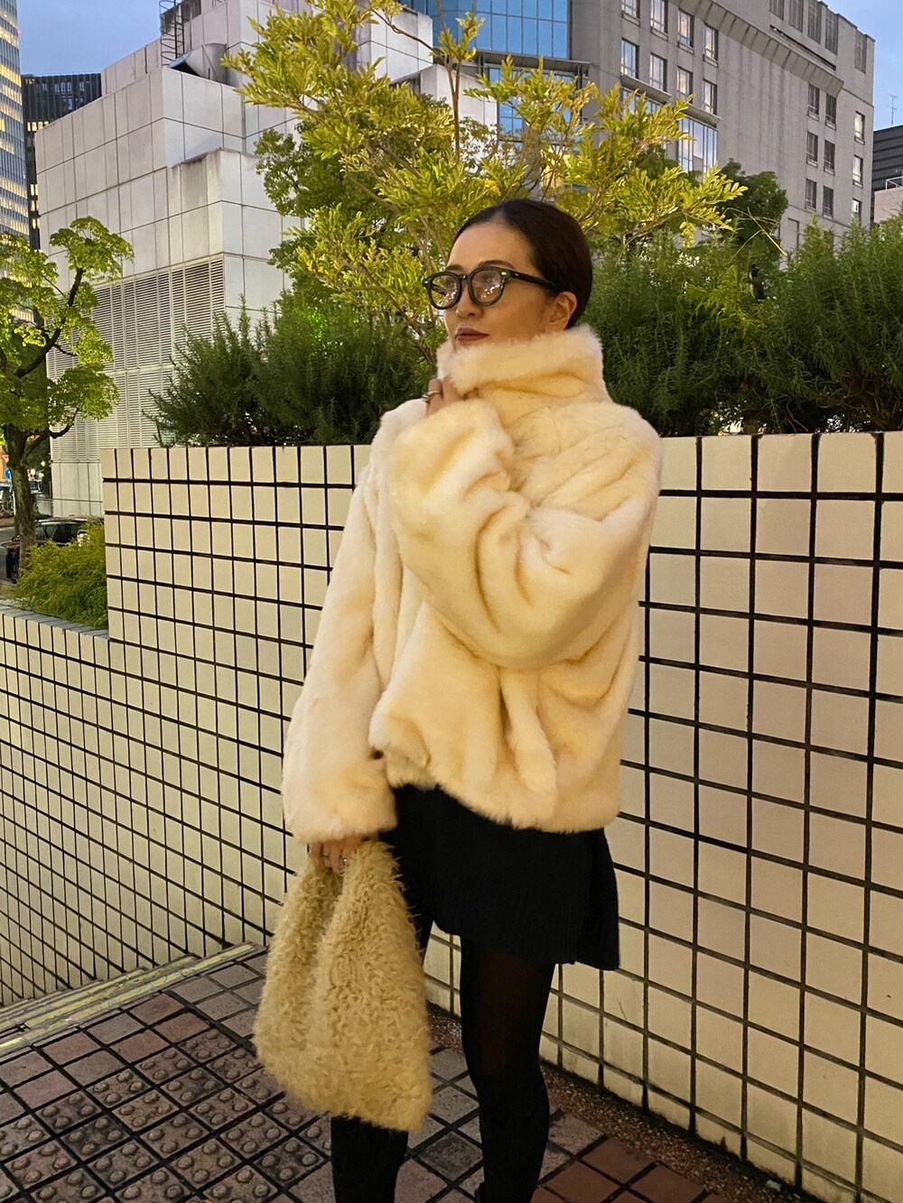 ホワイト系のブルゾン、ブラック系のブーツを着用したレディースの冬コーディネートの5枚目の写真