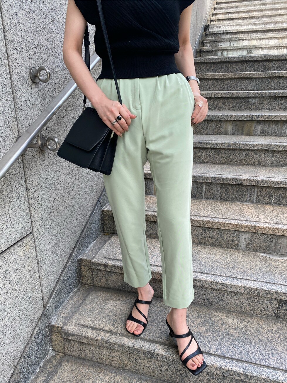 グリーン系のその他パンツ、ブラック系のサンダル、ブラック系のハンドバッグを着用したレディースの春コーディネートの2枚目の写真