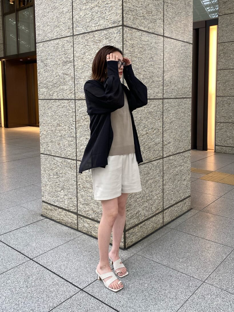 ホワイト系のサンダル、ブラック系のシャツ/ブラウス、ベージュ系のタンクトップを着用したレディースの春コーディネートの4枚目の写真
