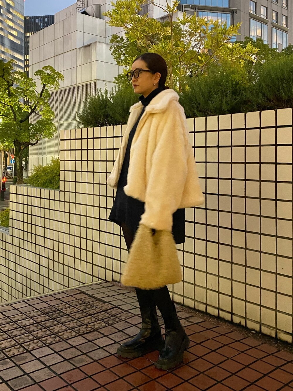 ホワイト系のブルゾン、ブラック系のブーツを着用したレディースの冬コーディネートの3枚目の写真