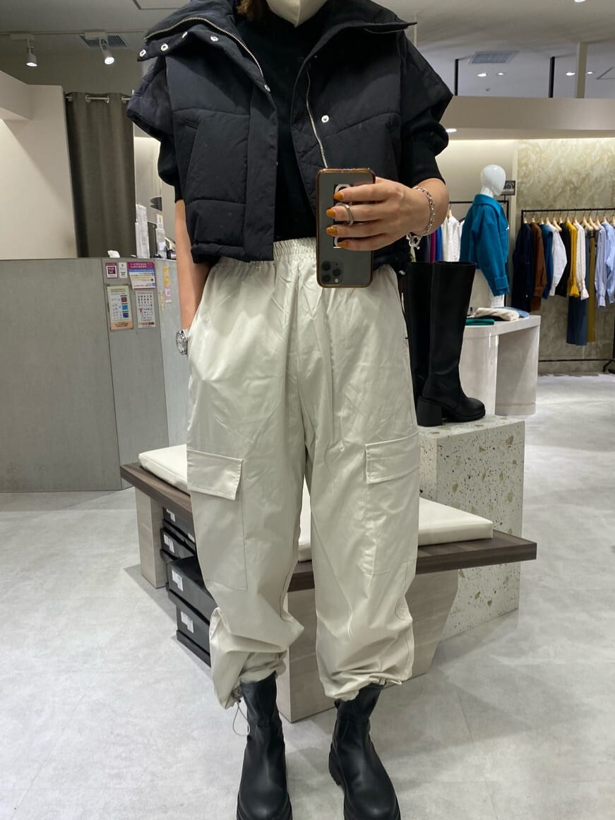 ブラック系のダウンベスト、ブラック系のニット/セーター、ホワイト系のカーゴパンツを着用したレディースの秋コーディネートの4枚目の写真