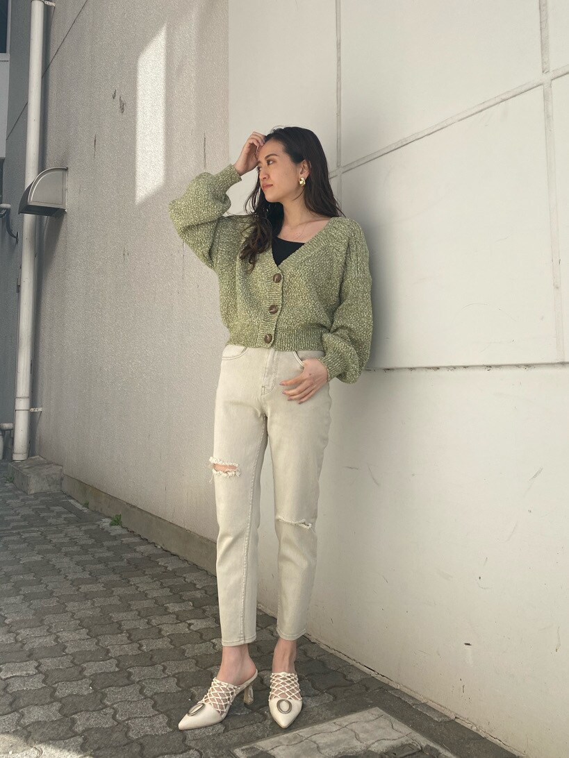 グリーン系のカーディガン/ボレロ、ホワイト系のパンプス、ゴールド系のイヤリングを着用したレディースの冬コーディネートの2枚目の写真