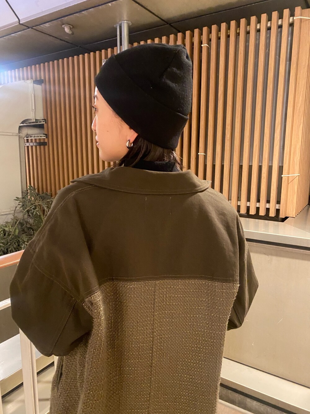 グリーン系のブルゾン、グリーン系のカーゴパンツ、ブラック系のニット/セーターを着用したレディースの冬コーディネートの5枚目の写真