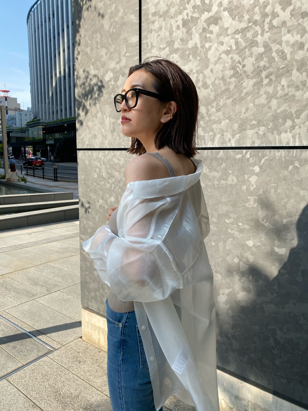 ホワイト系のサンダル、ブルー系のデニムパンツ、ベージュ系のニット/セーターを着用したレディースの春コーディネートの2枚目の写真