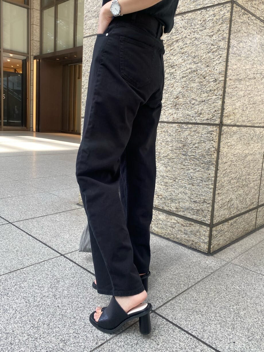 ブラック系のデニムパンツ、ブラック系のサンダルを着用したレディースの春コーディネートの6枚目の写真