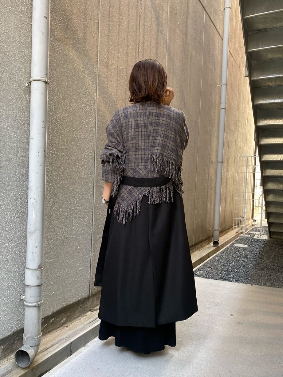 ブラック系のトレンチコートを着用したレディースの夏コーディネートの3枚目の写真