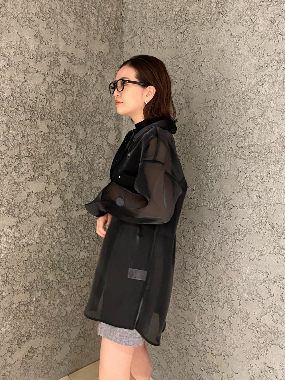 グレー系のスラックス、ブラック系のシャツ/ブラウス、ブラック系のニット/セーターを着用したレディースの春コーディネートの6枚目の写真