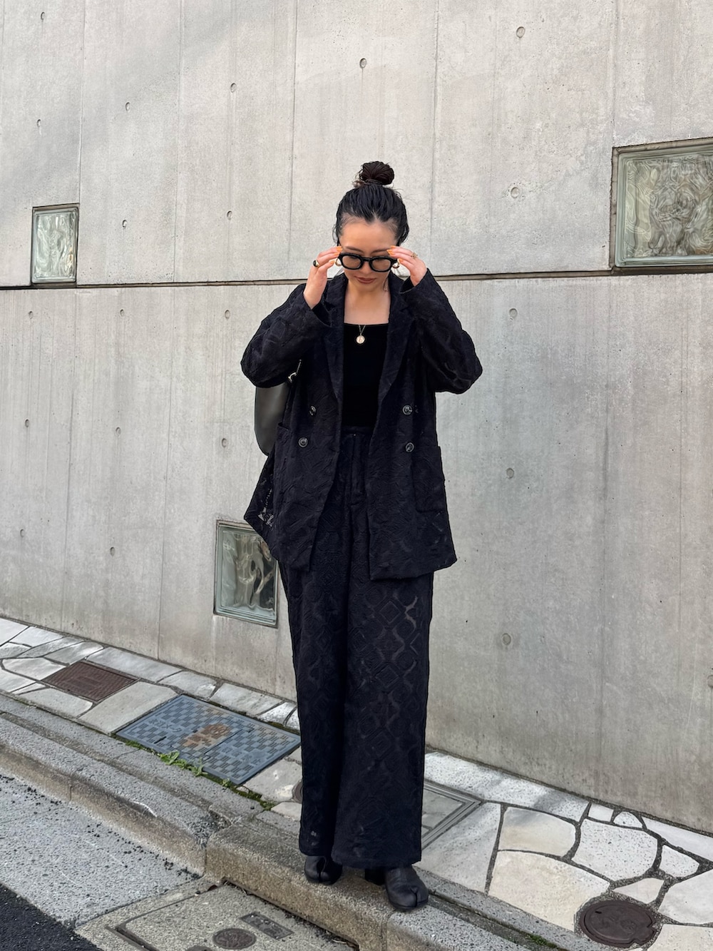 ブラック系のテーラードジャケット、ブラック系のその他パンツを着用したレディースの春コーディネートの2枚目の写真