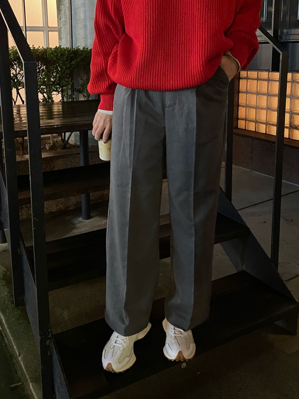 グレー系のスラックス、レッド系のニット/セーターを着用したレディースの秋コーディネートの3枚目の写真