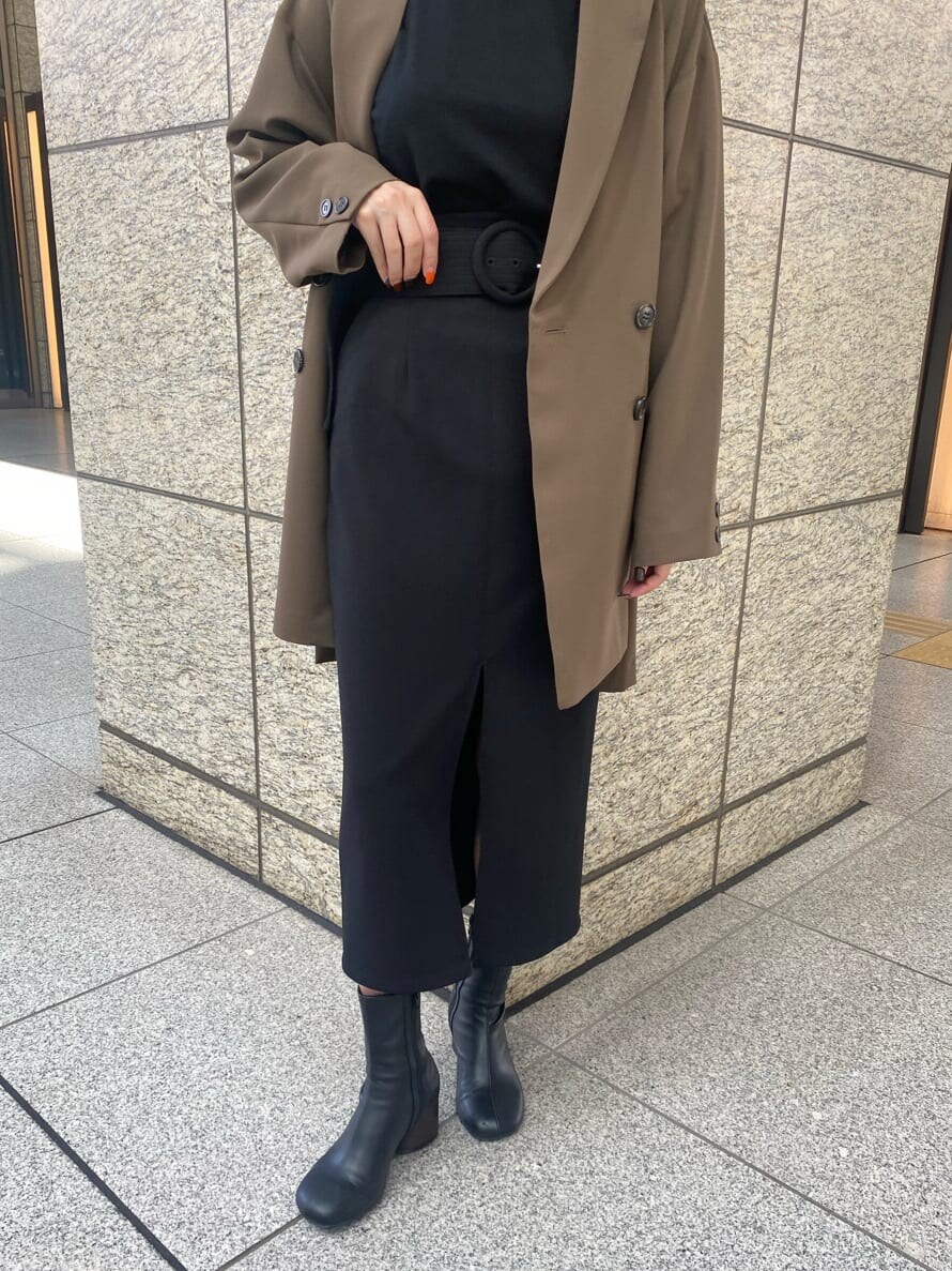 ブラック系のニット/セーター、ブラック系のスカート、ベージュ系のテーラードジャケットを着用したレディースの秋コーディネートの5枚目の写真