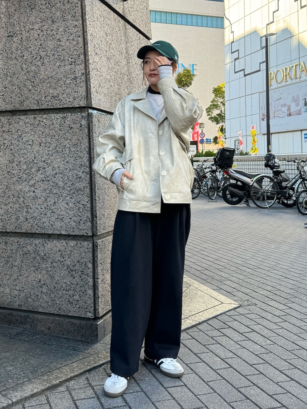 ホワイト系のブルゾン、グリーン系のキャップを着用したレディースの冬コーディネートの2枚目の写真