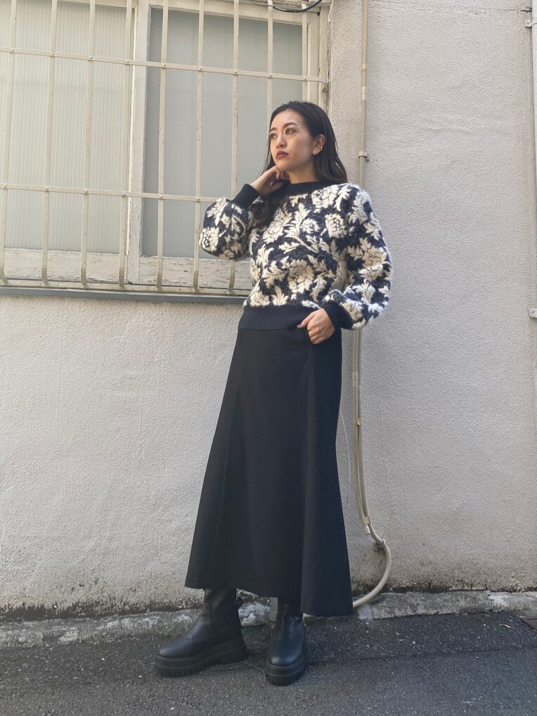 ブラック系のダウンジャケット/コート、ブラック系のスカート、ブラック系のニット/セーターを着用したレディースの秋コーディネートの2枚目の写真