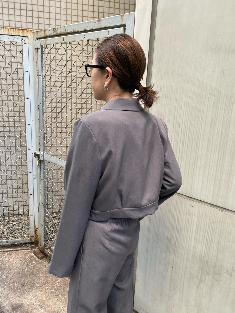 グレー系のテーラードジャケット、ブラック系のニット/セーター、グレー系のスラックスを着用したレディースの冬コーディネートの7枚目の写真