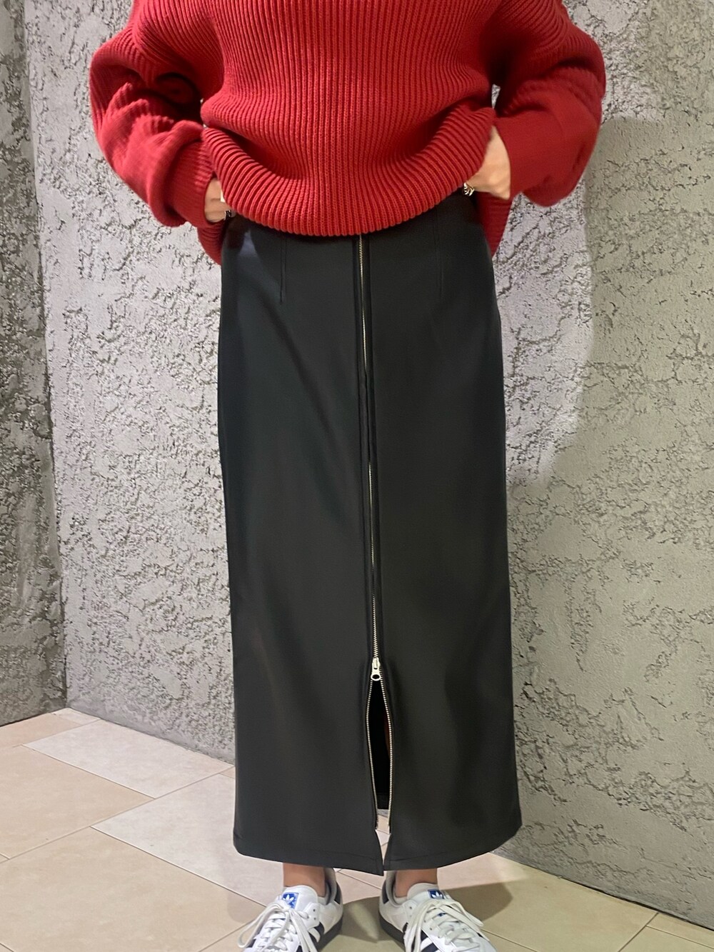 レッド系のニット/セーター、ブラック系のスカートを着用したレディースの冬コーディネートの5枚目の写真