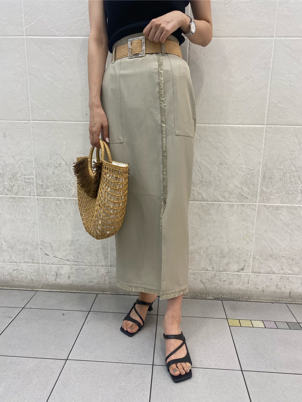 ブラック系のサンダル、ベージュ系のかごバッグ、ホワイト系のスカートを着用したレディースの春コーディネートの5枚目の写真