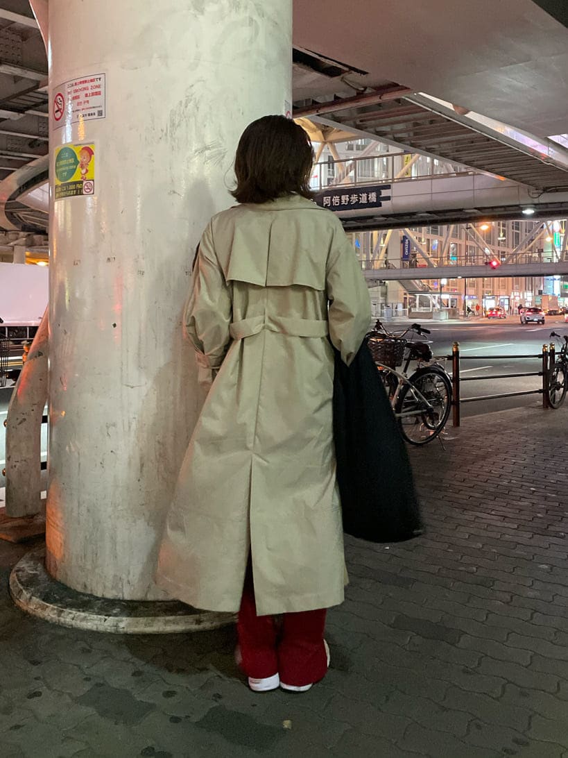 ベージュ系のトレンチコート、ブラック系のTシャツ/カットソー、シルバー系のピアス（両耳用）を着用したレディースの春コーディネートの5枚目の写真