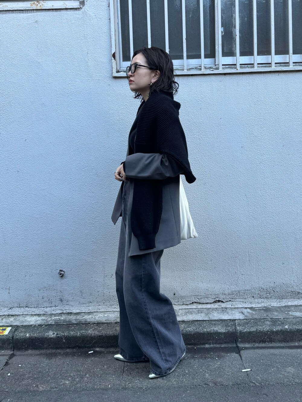 ブラック系のデニムパンツを着用したレディースの春コーディネートの2枚目の写真