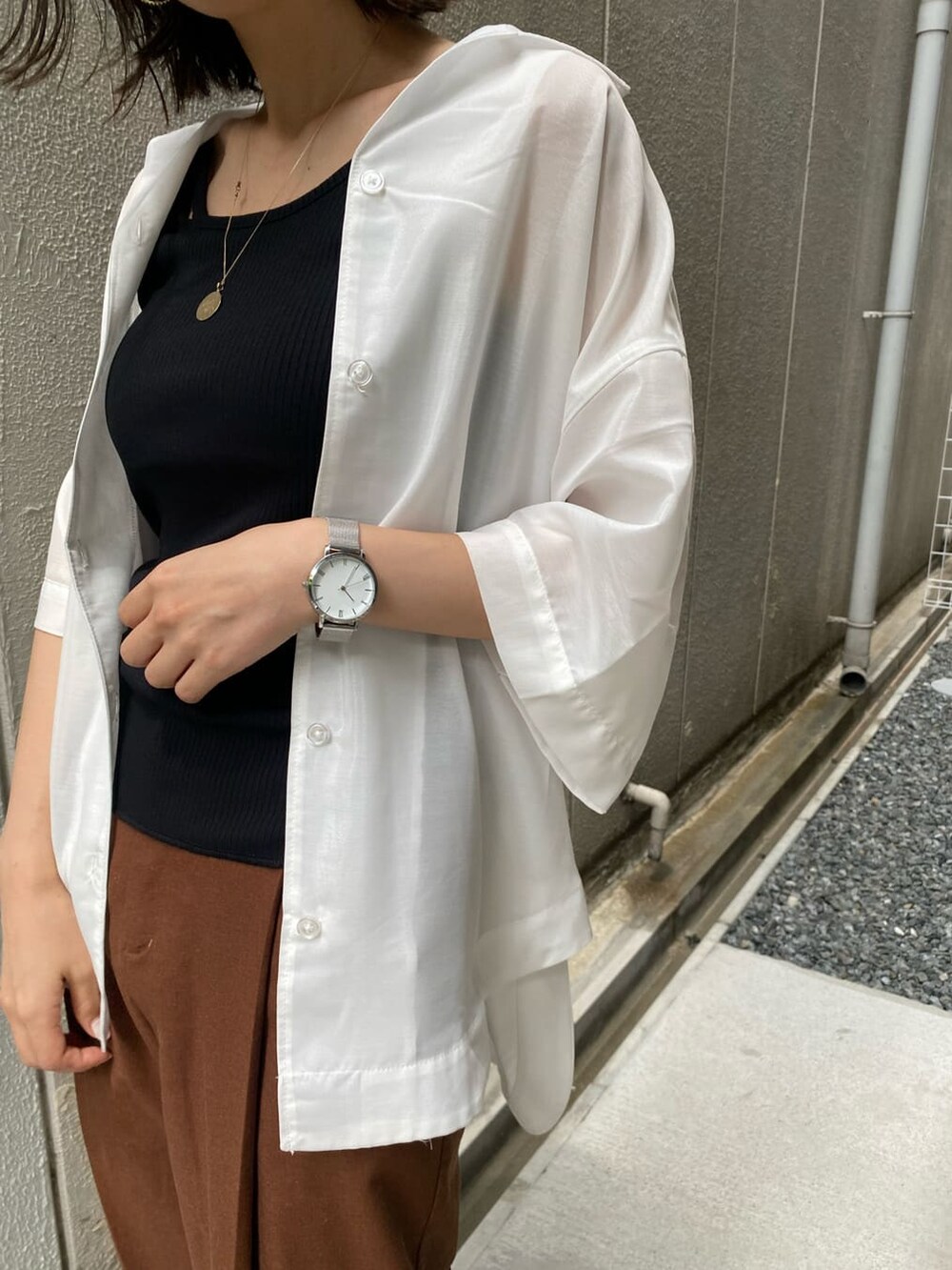 ホワイト系のシャツ/ブラウス、ブラック系のサンダル、ブラック系のTシャツ/カットソーを着用したレディースの夏コーディネートの6枚目の写真