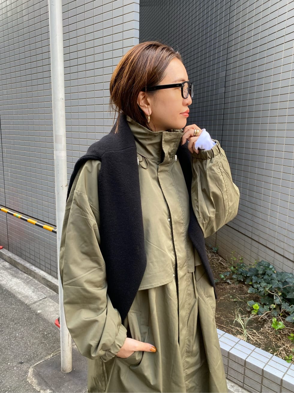 ブラック系のニット/セーター、ホワイト系のTシャツ/カットソー、グリーン系のその他アウターを着用したレディースの秋コーディネートの6枚目の写真