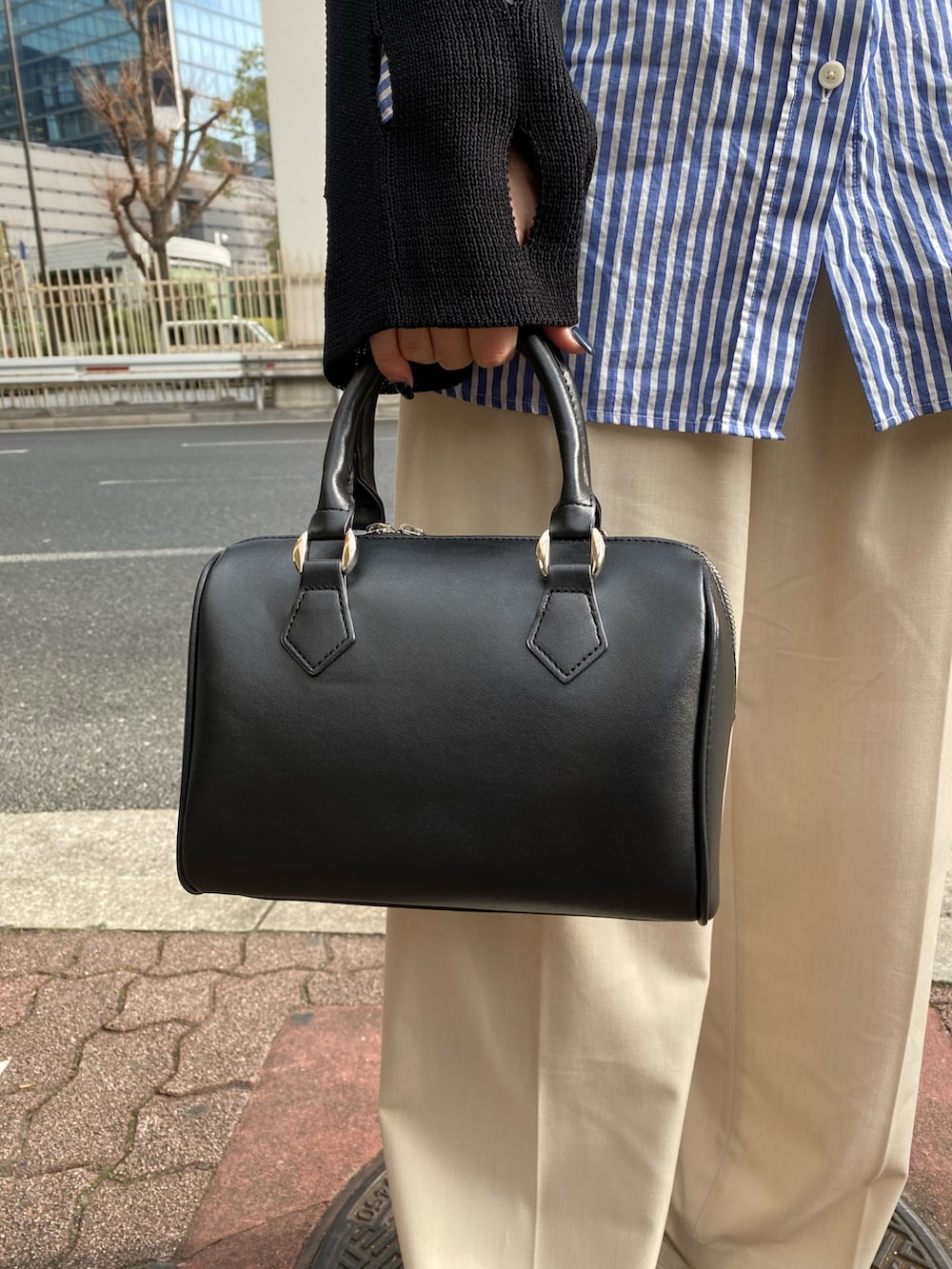 ブラック系のニット/セーター、ブラック系のハンドバッグを着用したレディースの冬コーディネートの7枚目の写真