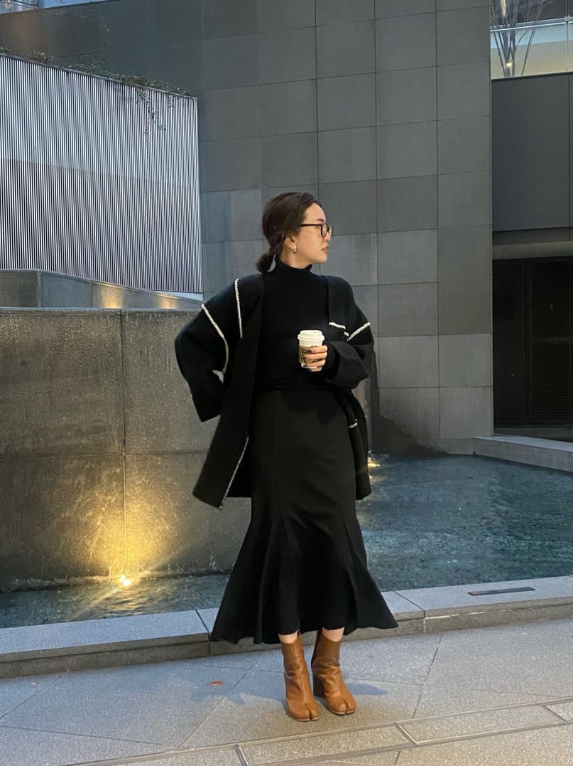 ブラック系のニット/セーター、ブラック系のスカート、ブラック系のカーディガン/ボレロを着用したレディースの冬コーディネートの2枚目の写真