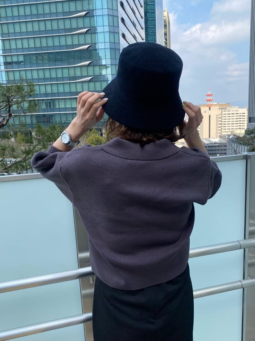 ブラック系のスカート、グレー系のニット/セーター、ブラック系のハットを着用したレディースの春コーディネートの7枚目の写真