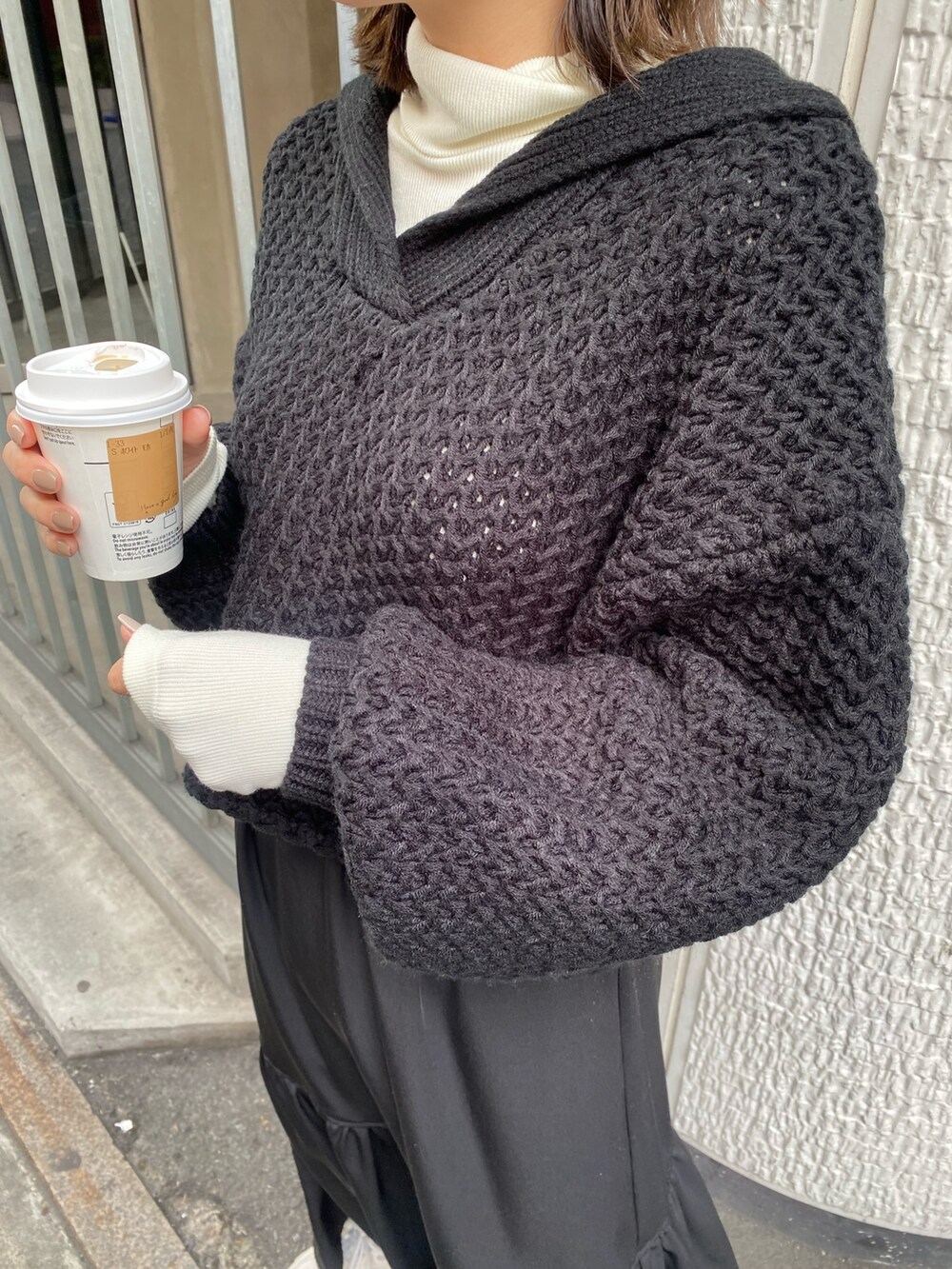 ブラック系のスカート、ホワイト系のニット/セーターを着用したレディースの冬コーディネートの4枚目の写真