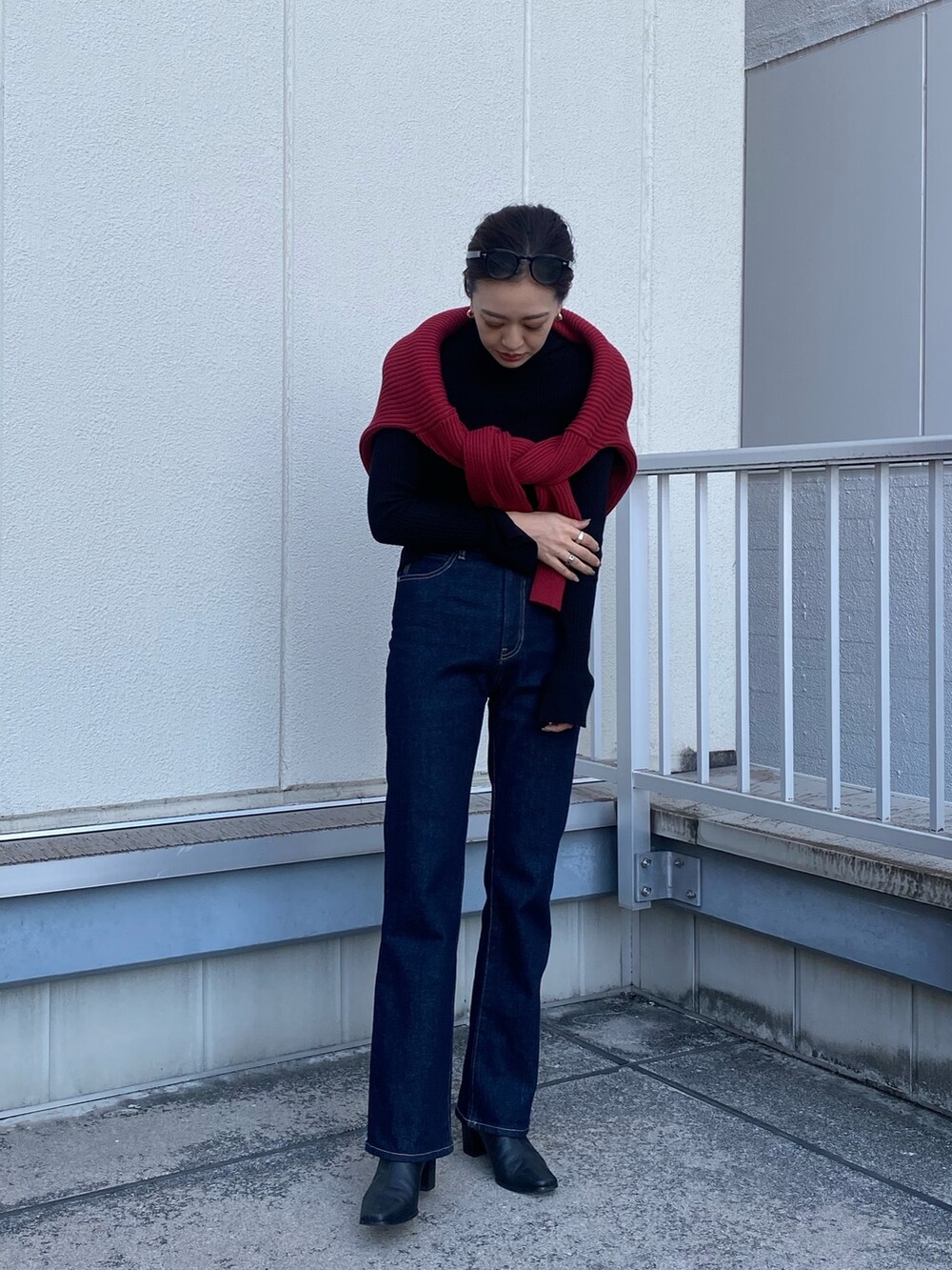 ブルー系のデニムパンツ、レッド系のニット/セーターを着用したレディースの冬コーディネートの2枚目の写真