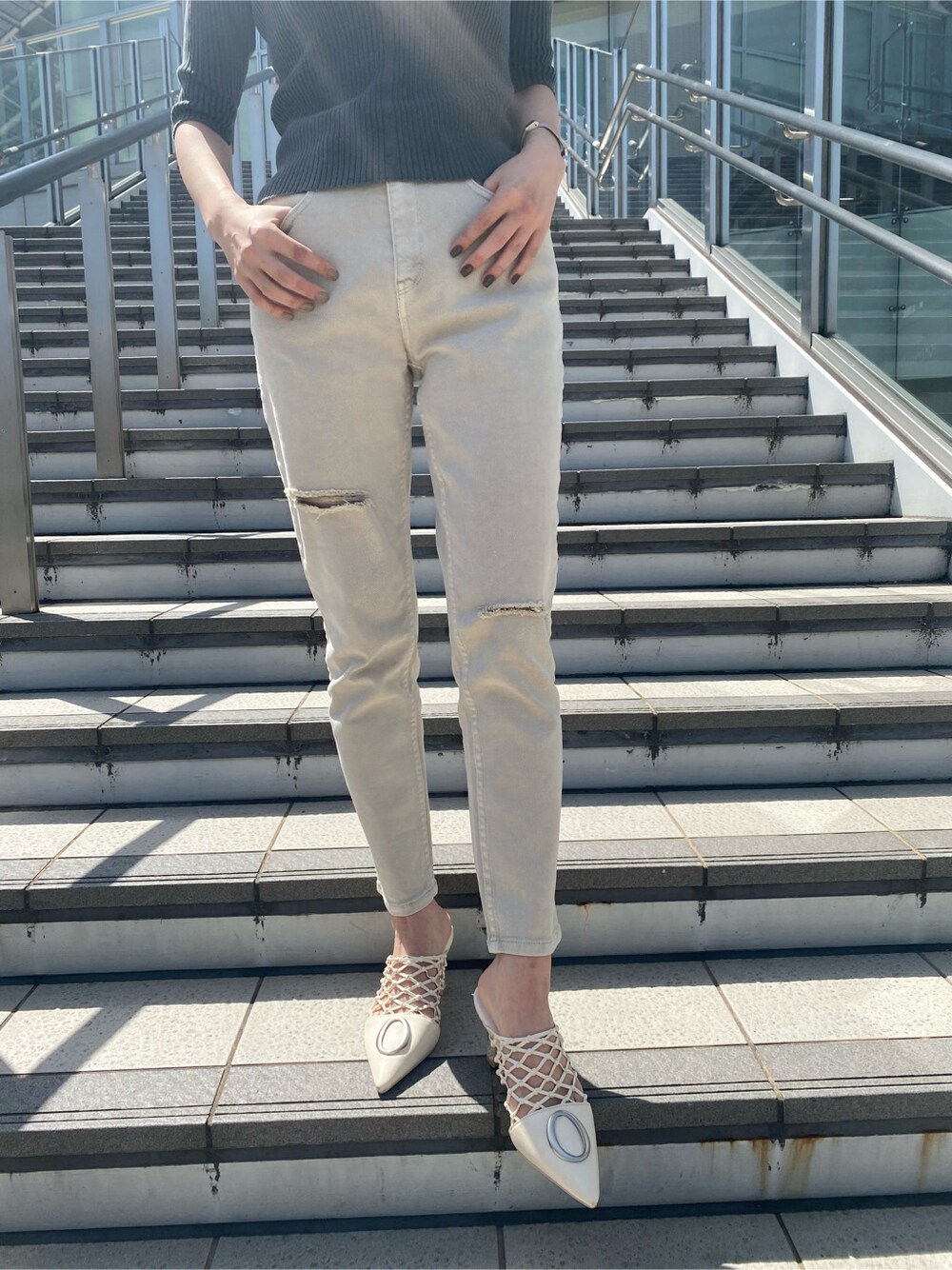 ホワイト系のシャツ/ブラウス、グレー系のその他パンツ、ブラック系のニット/セーターを着用したレディースの春コーディネートの7枚目の写真