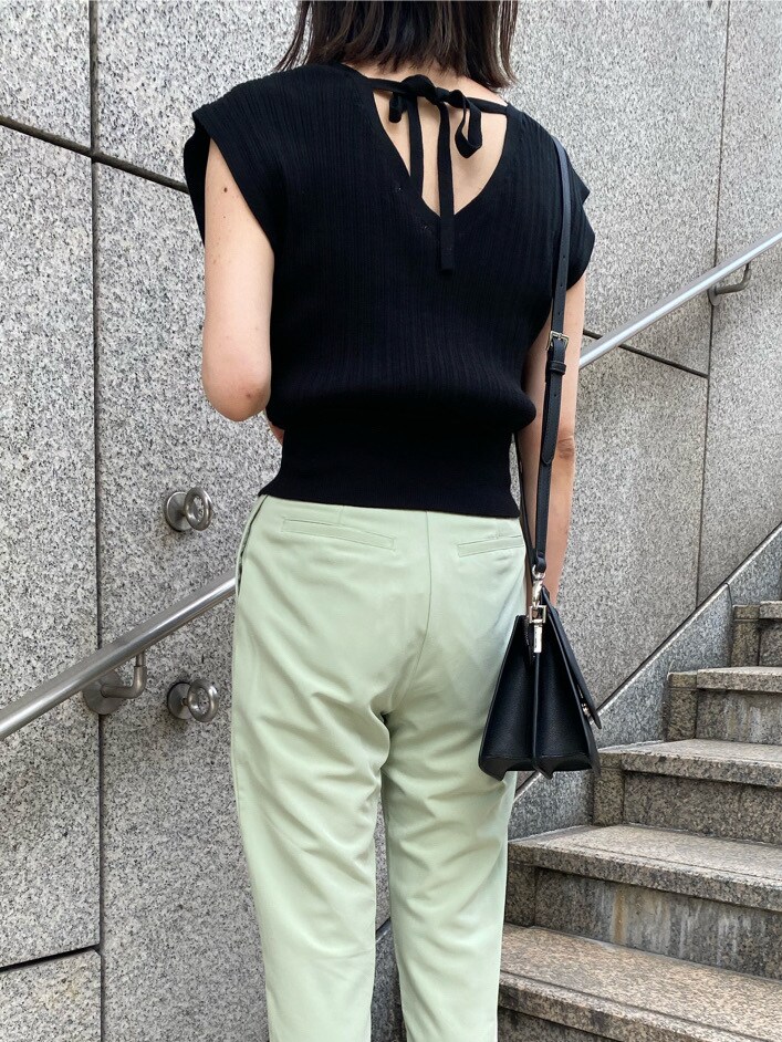 グリーン系のその他パンツ、ブラック系のサンダル、ブラック系のハンドバッグを着用したレディースの春コーディネートの3枚目の写真