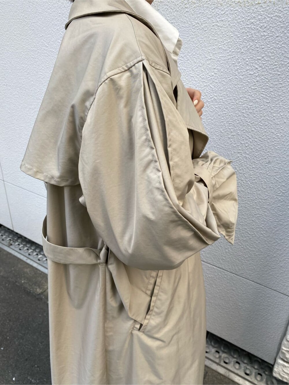 ベージュ系のトレンチコートを着用したレディースの春コーディネートの8枚目の写真