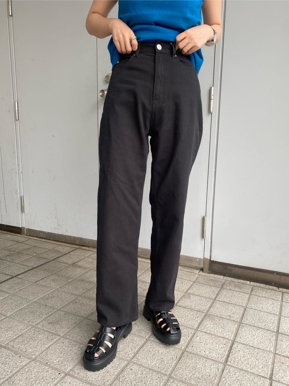 ブラック系のテーラードジャケット、ブラック系のデニムパンツ、ブラック系のサンダルを着用したレディースの春コーディネートの8枚目の写真