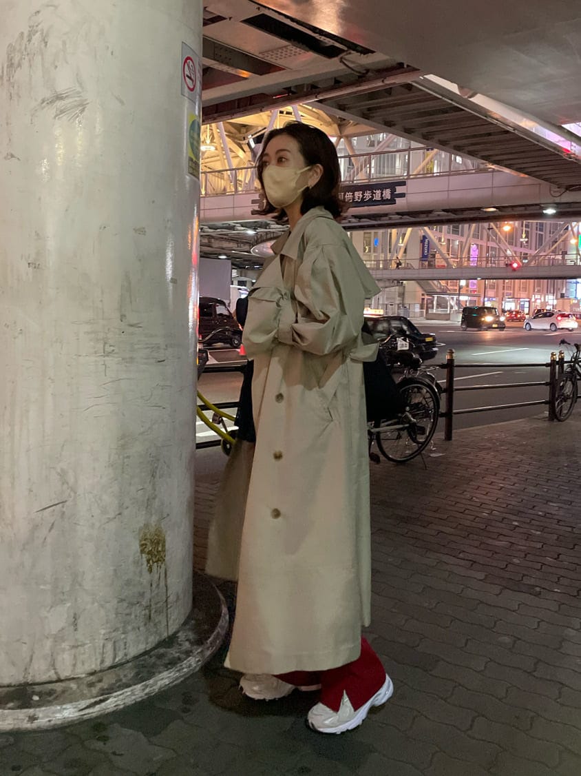 ベージュ系のトレンチコート、ブラック系のTシャツ/カットソー、シルバー系のピアス（両耳用）を着用したレディースの春コーディネートの3枚目の写真