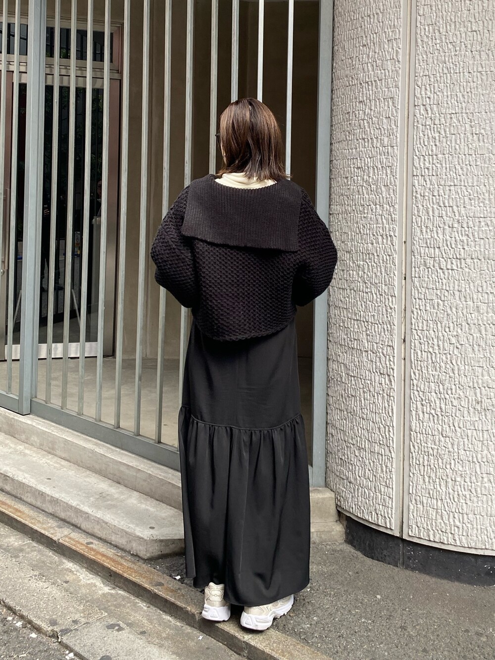 ブラック系のスカート、ホワイト系のニット/セーターを着用したレディースの冬コーディネートの3枚目の写真