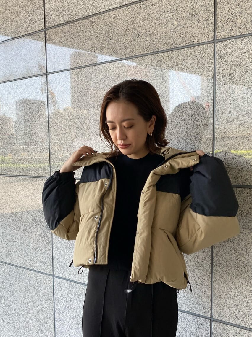 ブラック系のその他パンツ、ベージュ系のダウンジャケット/コート、ブラック系のブーツを着用したレディースの秋コーディネートの6枚目の写真