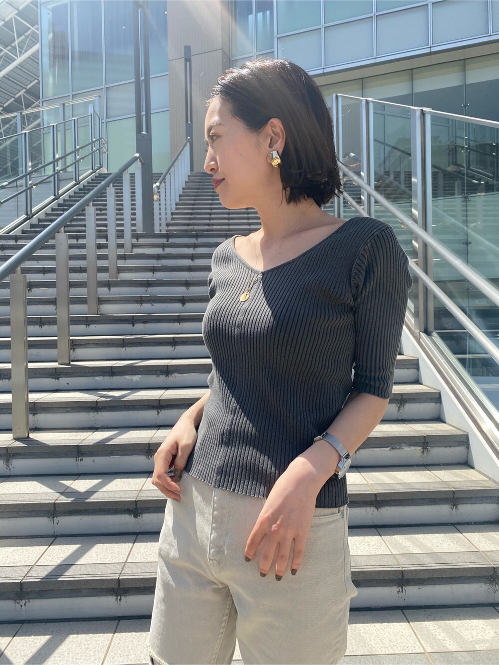 ホワイト系のシャツ/ブラウス、グレー系のその他パンツ、ブラック系のニット/セーターを着用したレディースの春コーディネートの6枚目の写真