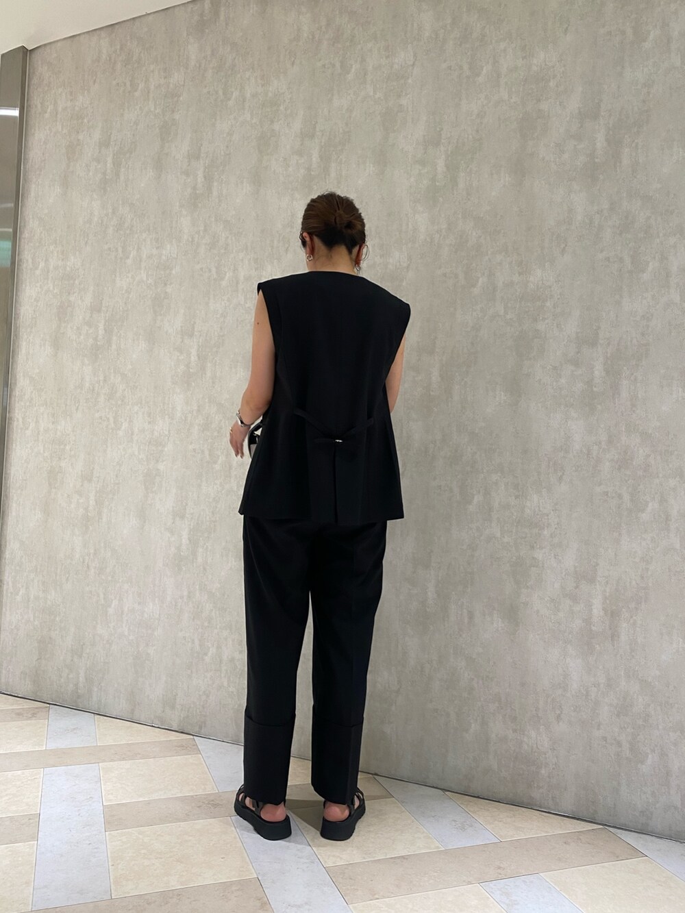 ブラック系のテーラードジャケット、ブラック系のスラックス、ブラック系のハンドバッグを着用したレディースの春コーディネートの3枚目の写真