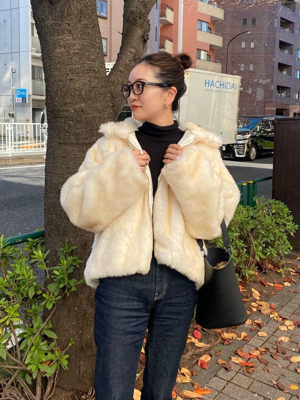 ホワイト系のブルゾン、ブルー系のデニムパンツを着用したレディースの冬コーディネートの7枚目の写真