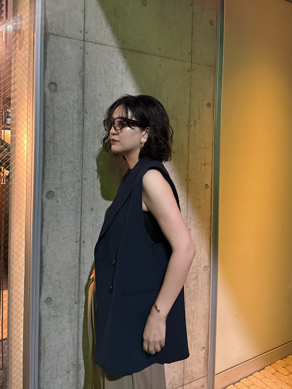 ブルー系のベストを着用したレディースの夏コーディネートの5枚目の写真