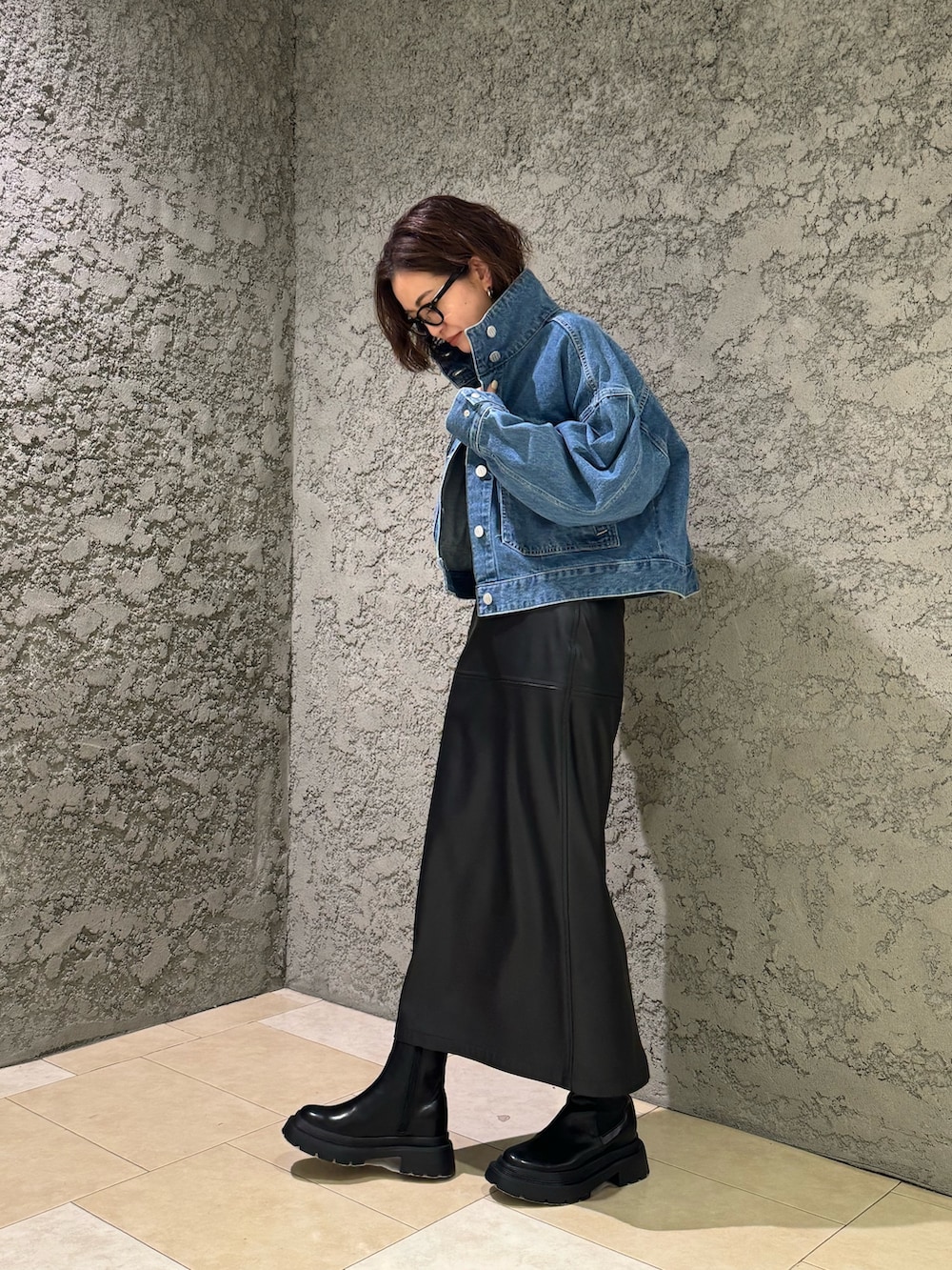 ブラック系のブーツ、ブルー系のデニムジャケットを着用したレディースの冬コーディネートの3枚目の写真