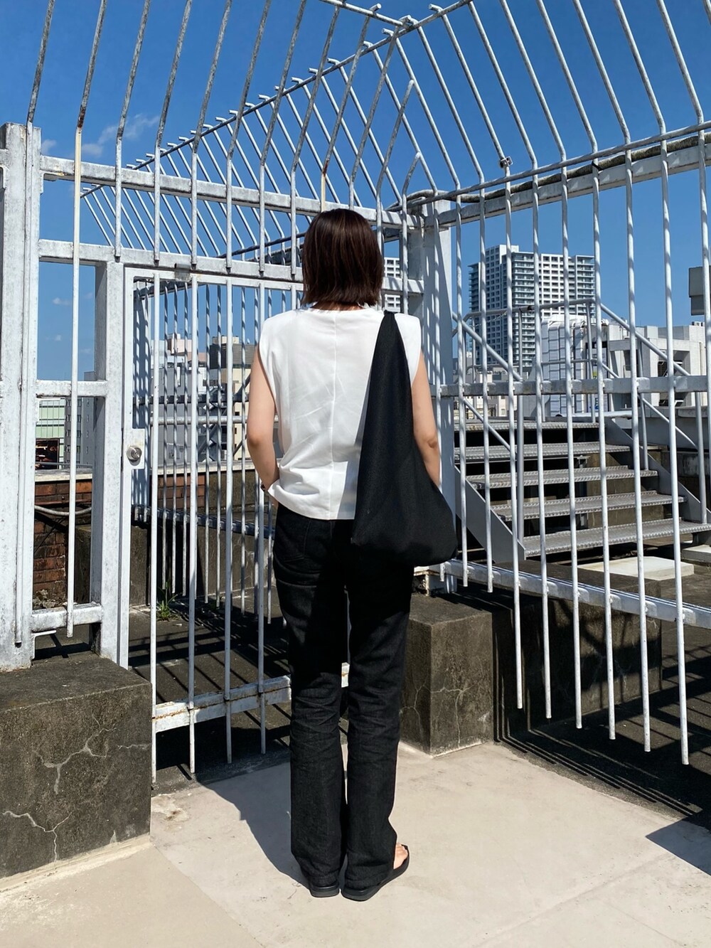 ホワイト系のTシャツ/カットソー、ブラック系のデニムパンツを着用したレディースの夏コーディネートの4枚目の写真