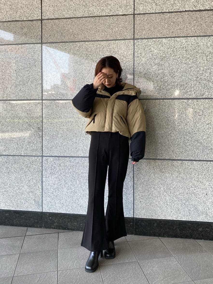ブラック系のその他パンツ、ベージュ系のダウンジャケット/コート、ブラック系のブーツを着用したレディースの秋コーディネートの5枚目の写真