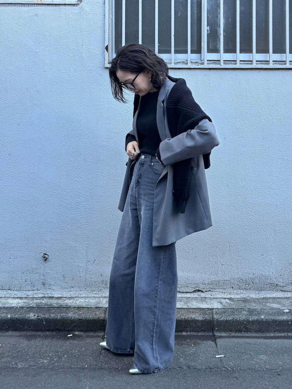 ブラック系のデニムパンツを着用したレディースの春コーディネートの3枚目の写真