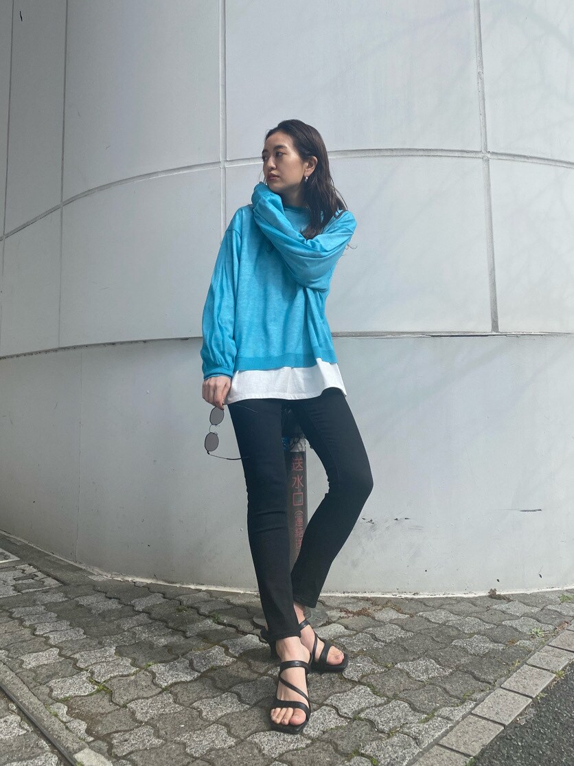 ブラック系のデニムパンツ、ブラック系のサンダル、ブルー系のニット/セーターを着用したレディースの冬コーディネートの2枚目の写真