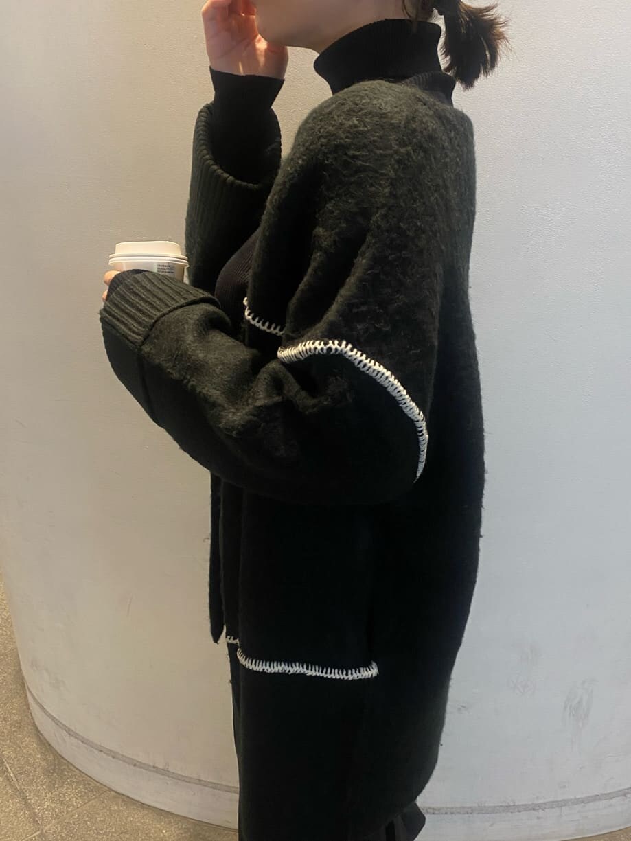 ブラック系のニット/セーター、ブラック系のスカート、ブラック系のカーディガン/ボレロを着用したレディースの冬コーディネートの6枚目の写真