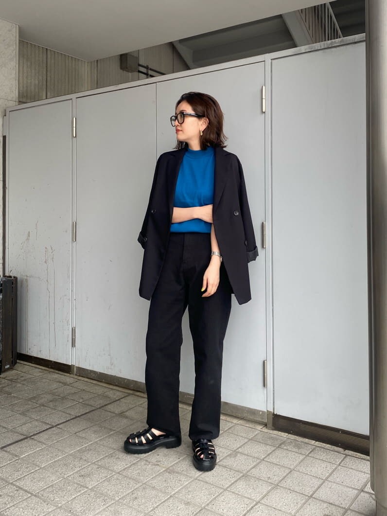 ブラック系のテーラードジャケット、ブラック系のデニムパンツ、ブラック系のサンダルを着用したレディースの春コーディネートの4枚目の写真