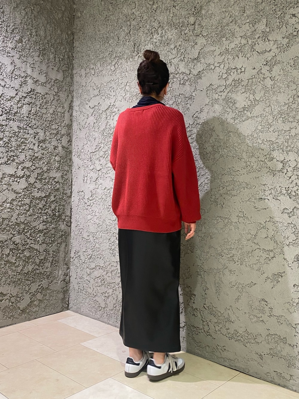 レッド系のニット/セーター、ブラック系のスカートを着用したレディースの冬コーディネートの3枚目の写真